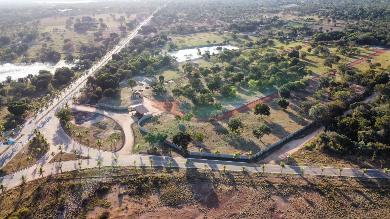 Vista aérea do empreendimento com vias internas e vegetação preservada